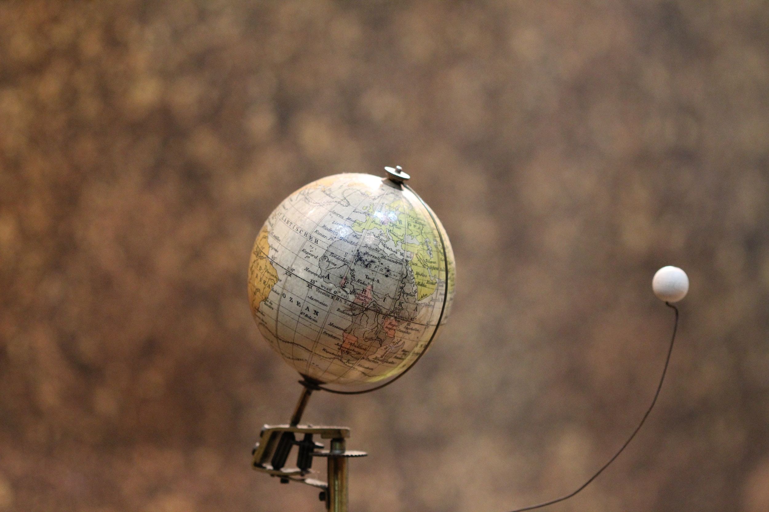 A dynamic digital illustration of a glowing globe with interconnected nodes, representing global scientific collaboration and discovery.