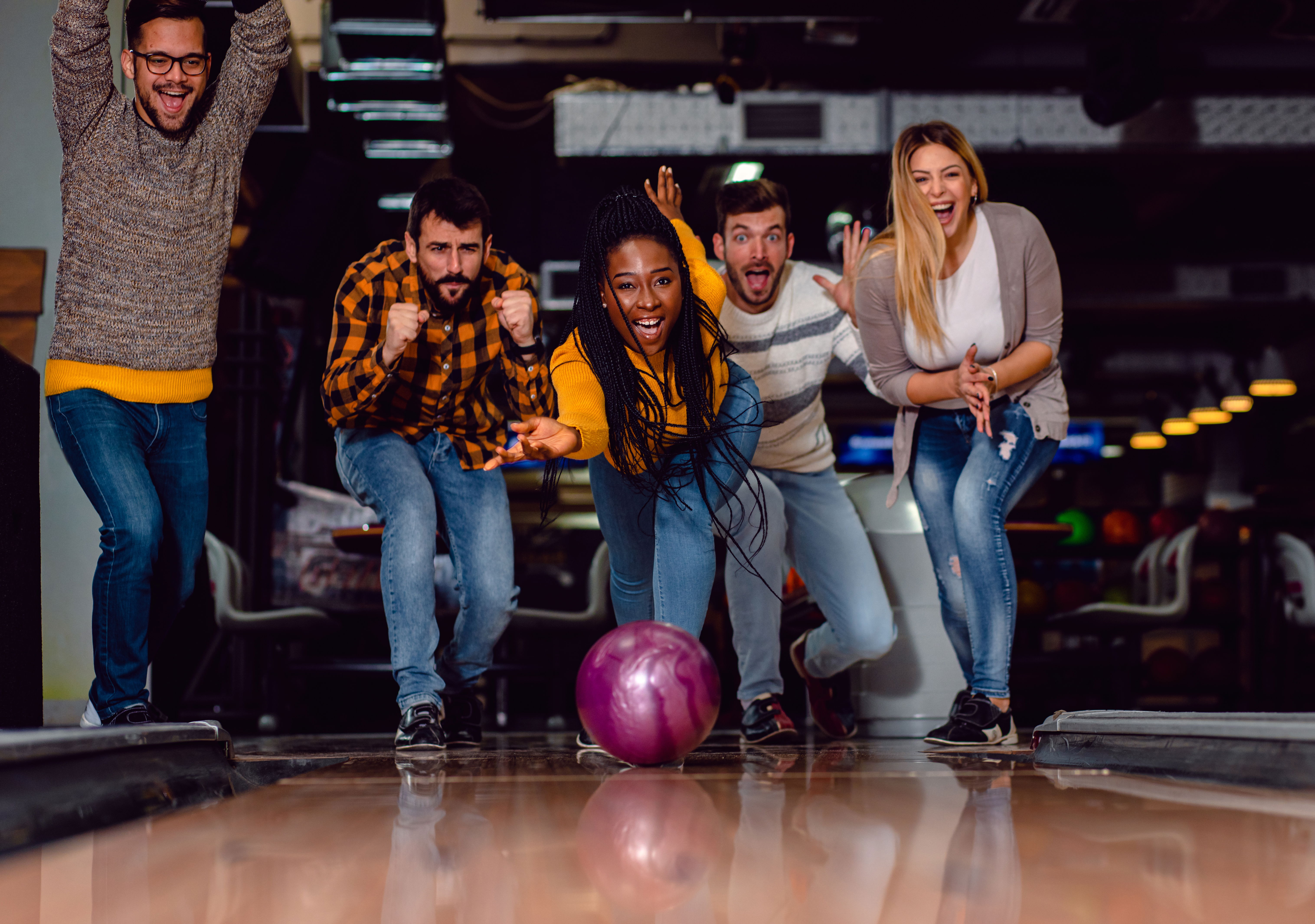 Group of friends out on a sober activity day, going bowling and laughing with joy.