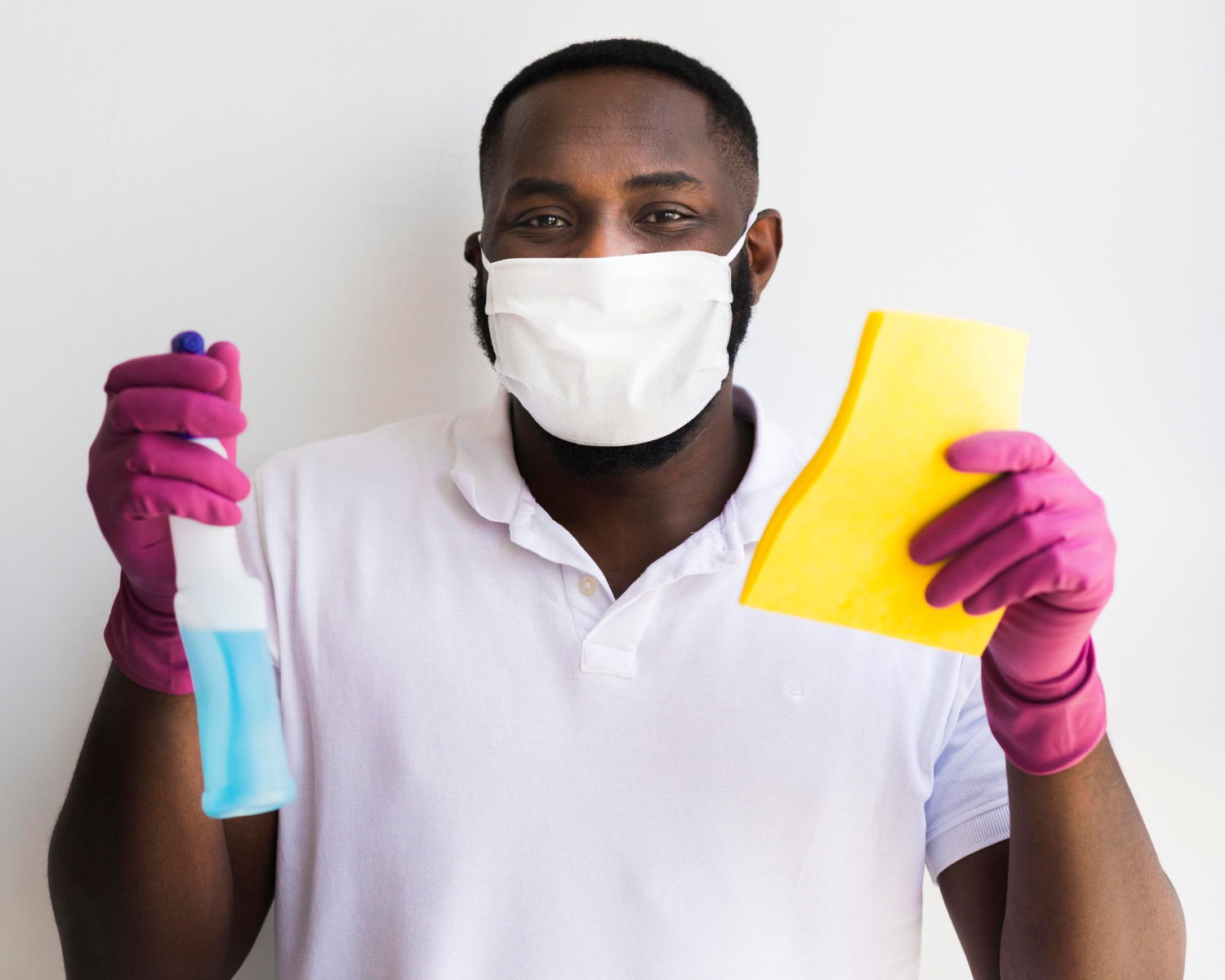 An African Man wearing facemask and holding a disinfectant