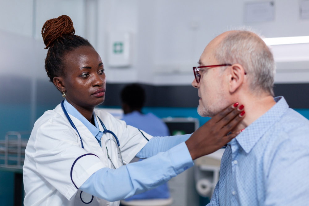 A female doctor examines an elderly male patient's neck in a clinic setting. 
