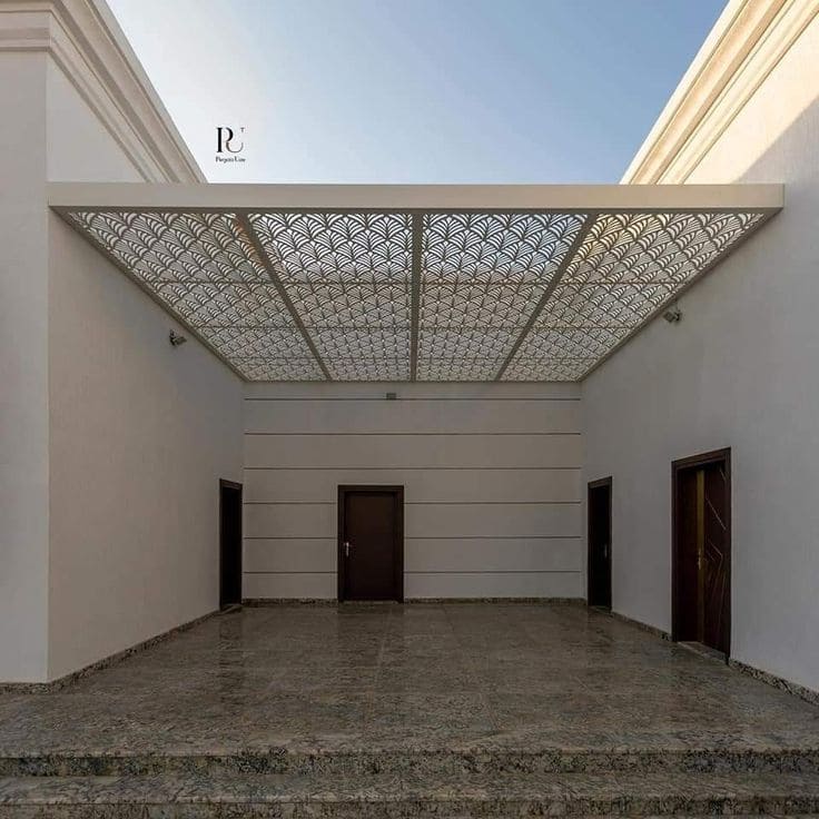مظلة حديدية بلون رمادي جامق تغطي سطح المنزل بالكامل، مصممة خصيصًا للجسم هندسيًا وتتحمل جمالية للواجهة.