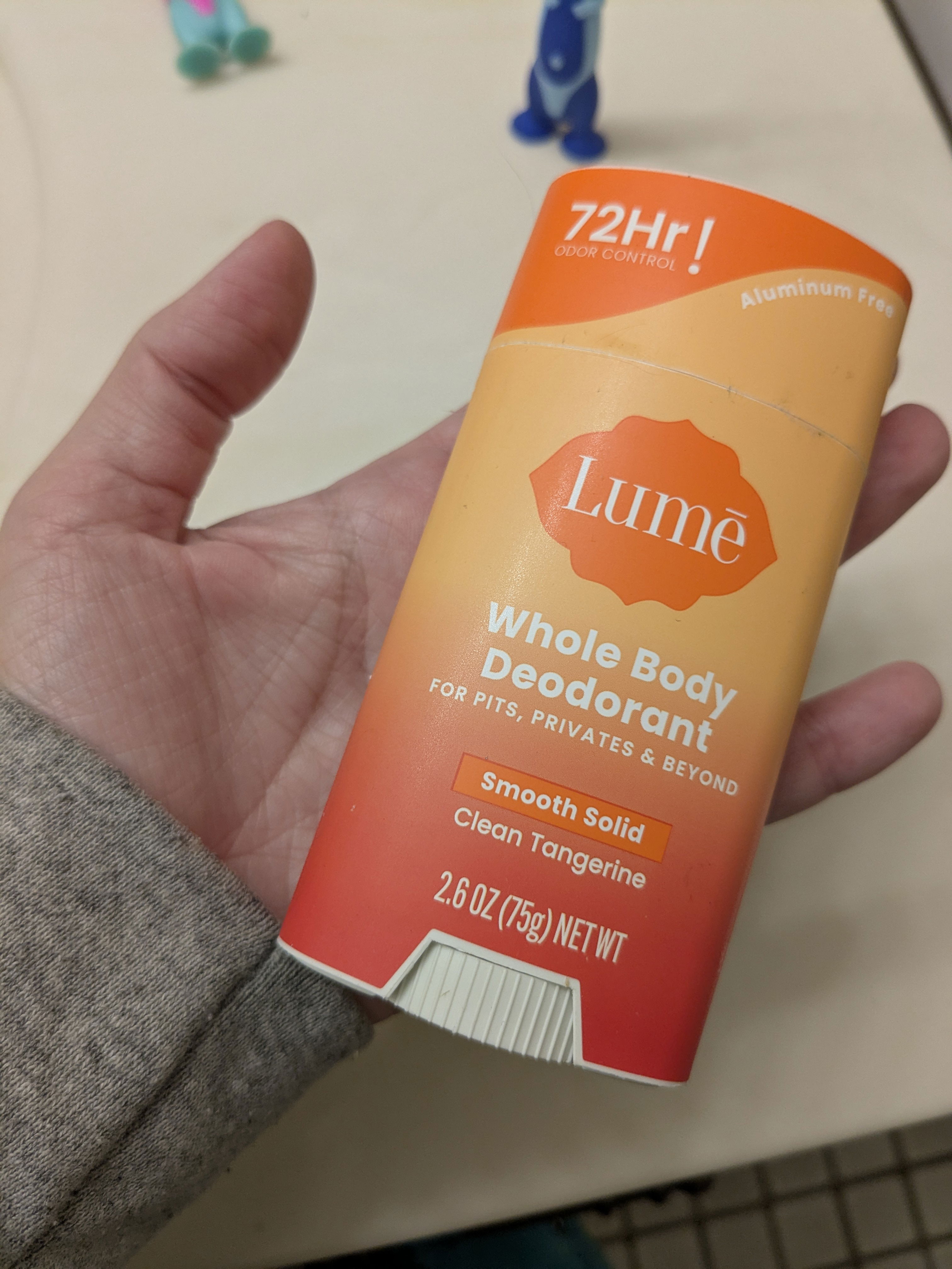 Lume deodorant in clean tangerine scent with a bathroom counter in the background