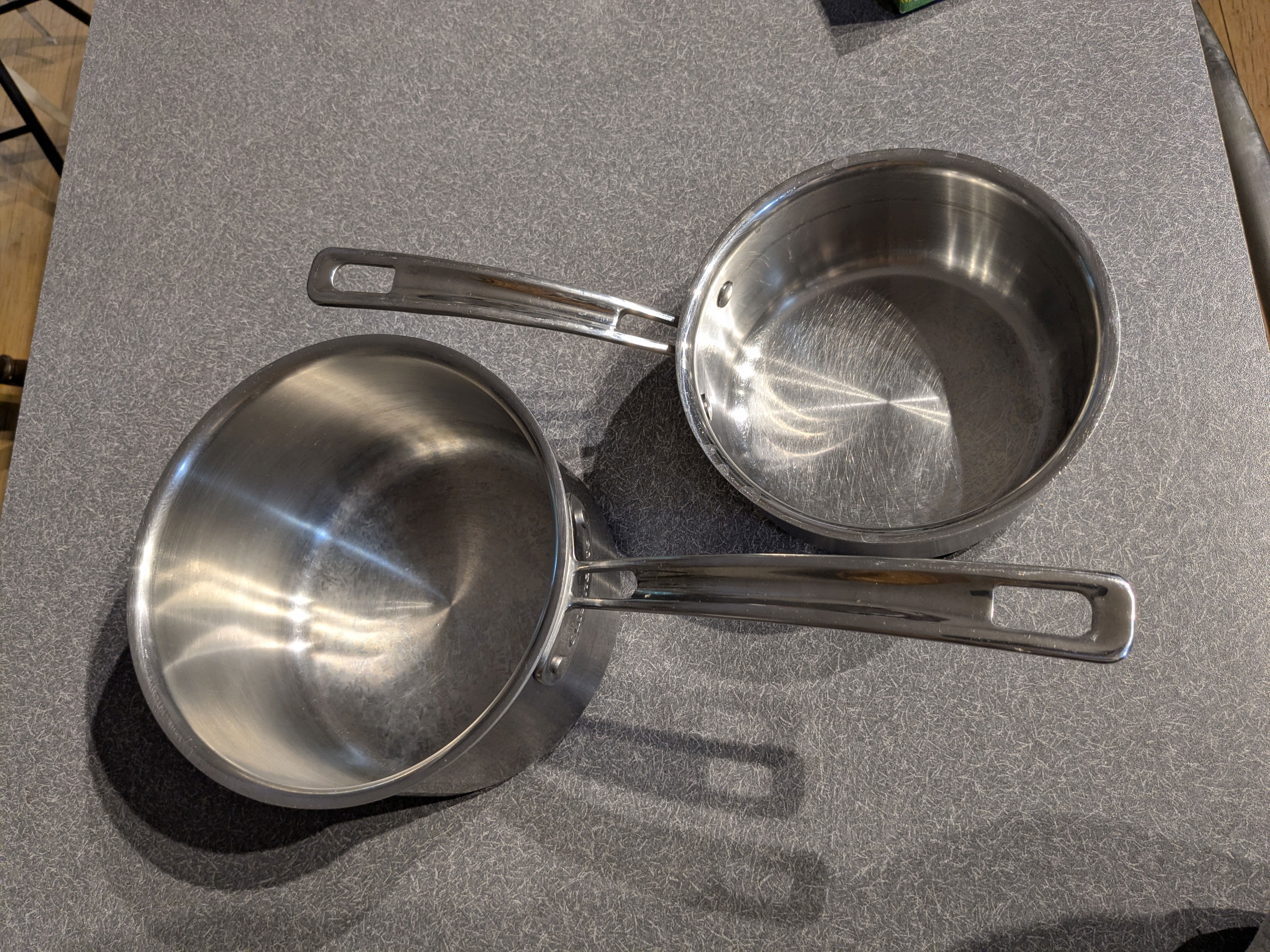 Two different size stainless steel pots are shown.