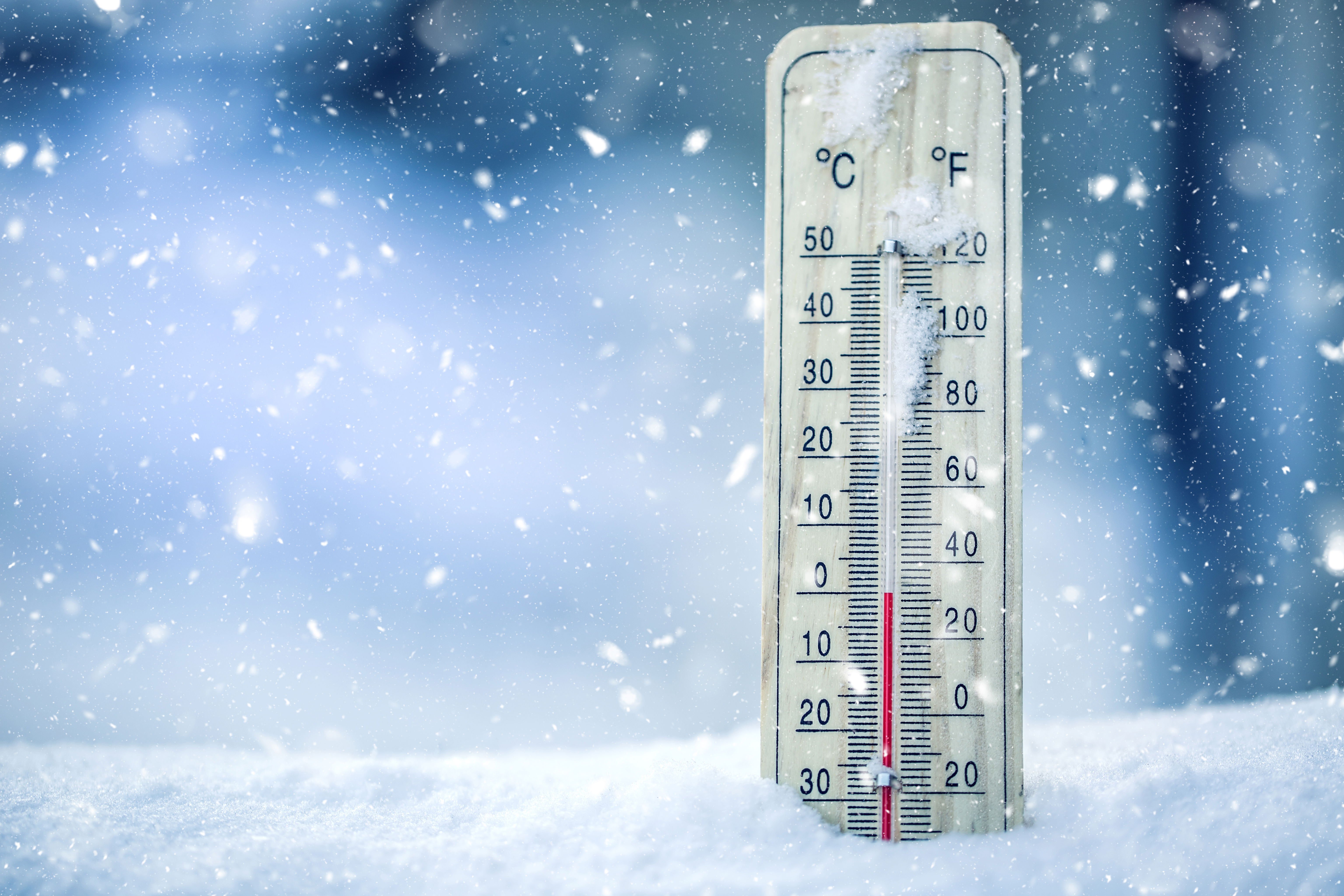A thermometer below freezing sitting in the snow