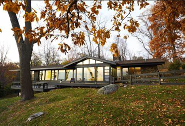A house with a large porch and a large treeAI-generated content may be incorrect.