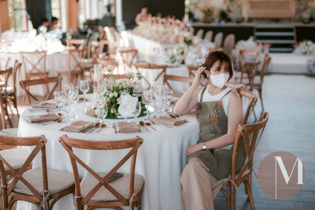 Kyne De la Peña, founder of M Catering and Events, smiling during an event styling setup