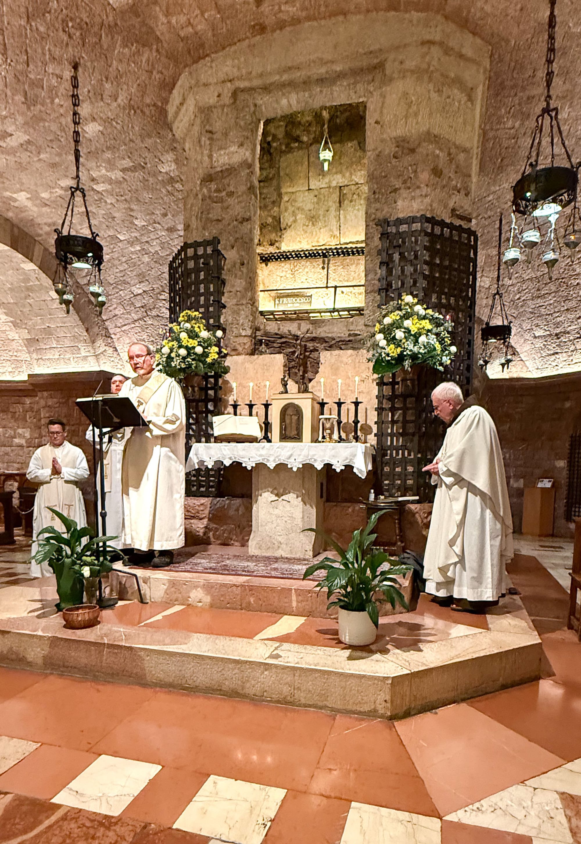 Proclaiming the Gospel at the altar at foot of the crypt with the body of St. Francis of Assisi