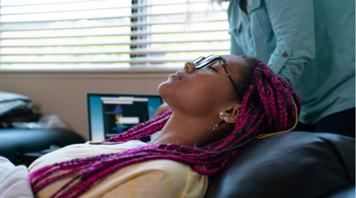 Picture of a woman laying down relaxed with eyes closed.