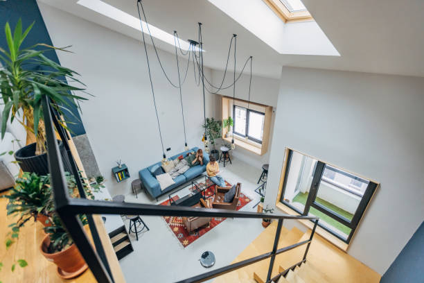 Spacious living room with a skylight and staircase, emphasizing the open design of a coliving space.