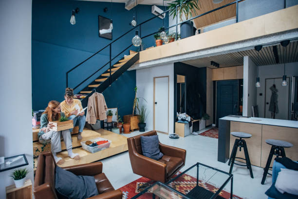A cozy living room featuring a staircase and a couch, designed for a coliving space atmosphere.