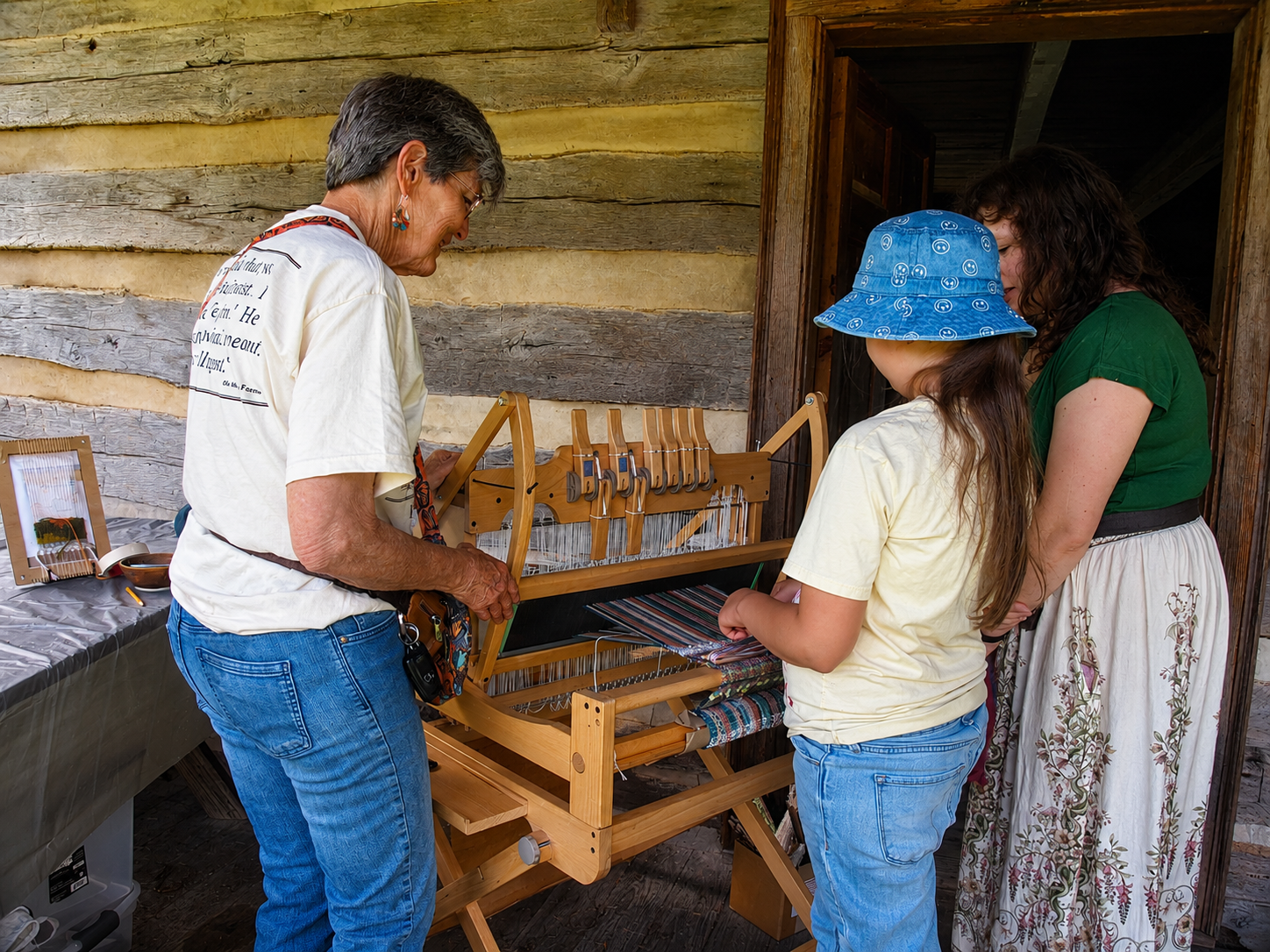 Kingsport Fun Fest: A girl is shown how to use a hand loom to create small textiles at Exchange Place Living History Farm's annual Farm Fest, Kingsport, TN, July 19, 2026 [Photo: S Cobaugh]
