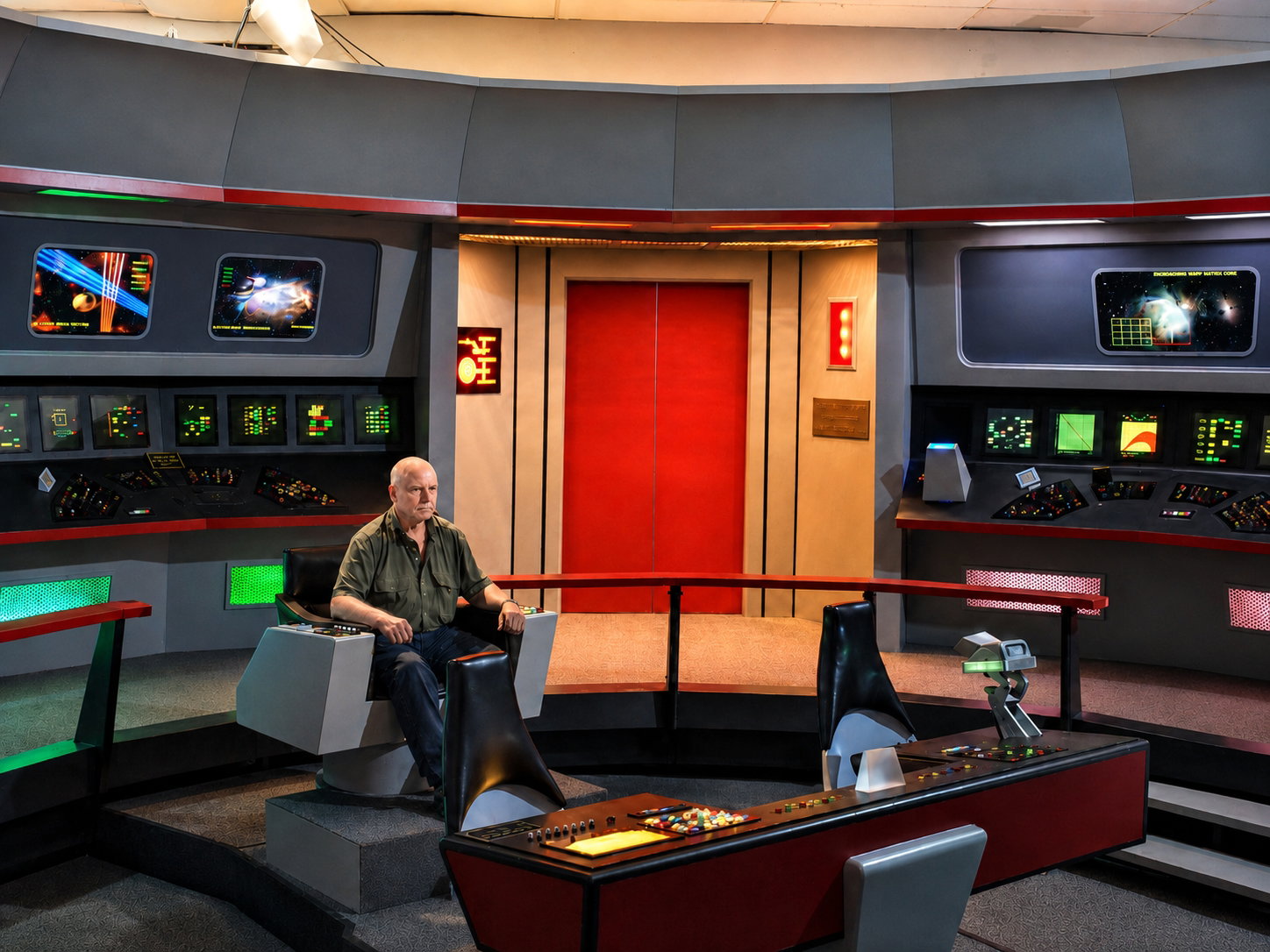 Stephen Cobaugh, Eventis Media News Director, poses in the captain's chair on the bridge of the U.S.S. Enterprise. Complete with working lights, sounds, and occasional intercom messages, the Star Trek Original Series Set tour in Ticonderoga, N.Y., brings visitors a sense of being on a mission in deep space. [Photo: D Dymond, Aug. 21, 2026]