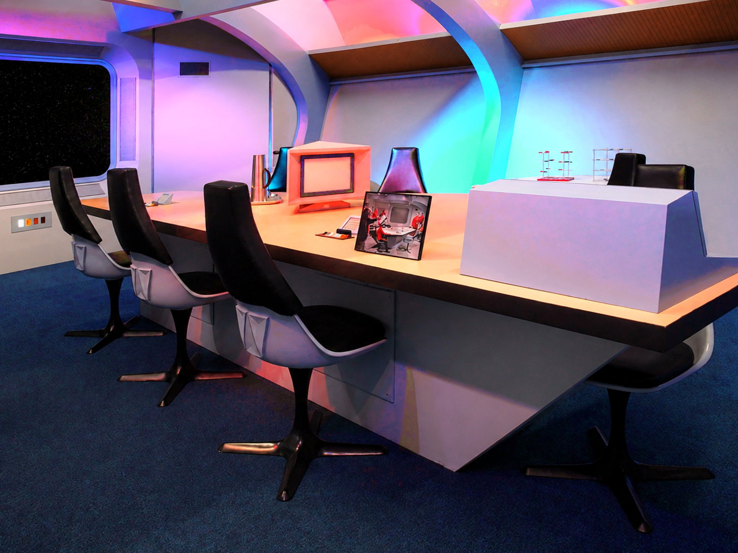 Chairs surround the briefing room table at the Star Trek Original Series Set Tour in Ticonderoga, N.Y. Like many of the sets, it was often transformed to substitute as other rooms during the series' three-year run. [Photo: S Cobaugh, Aug. 21, 2026]
