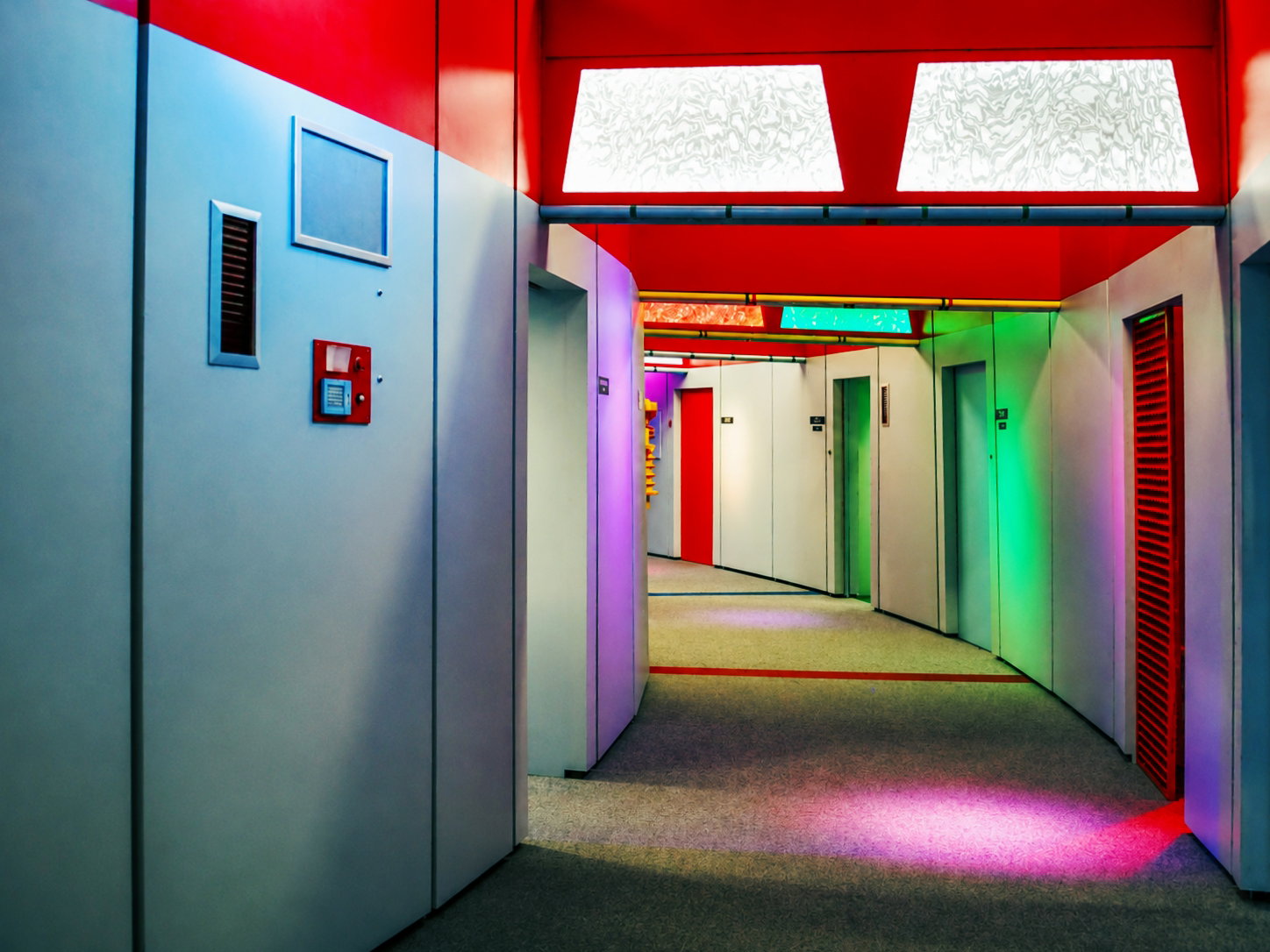 Recreating a classic Hollywood optical trick, the hallway on the Enterprise was curved to create the illusion of depth of field. The brightly-lit corridor in the Star Trek Original Series Set Tour in Ticonderoga, N.Y., was often filled with cast extras to suggest a large crew. [Photo: D Dymond, Aug. 21, 2026]