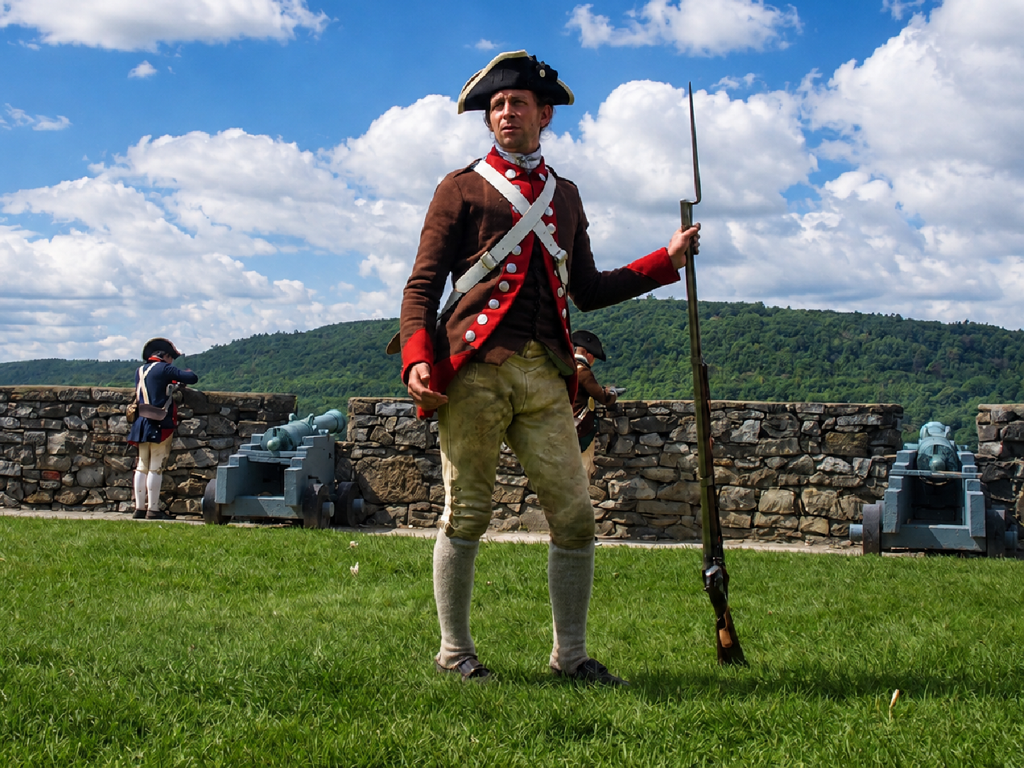 America 250: A living-history interpreter holds a flintlock musket during a military demonstration at Fort Ticonderoga in Ticonderoga, N.Y. The museum’s 2026 programming focuses on the Continental Army at Ticonderoga in 1776 and the weapons, equipment and skills soldiers relied upon to defend the northern approach to the new nation. [Photo: D Dymond, Aug. 22, 2026]