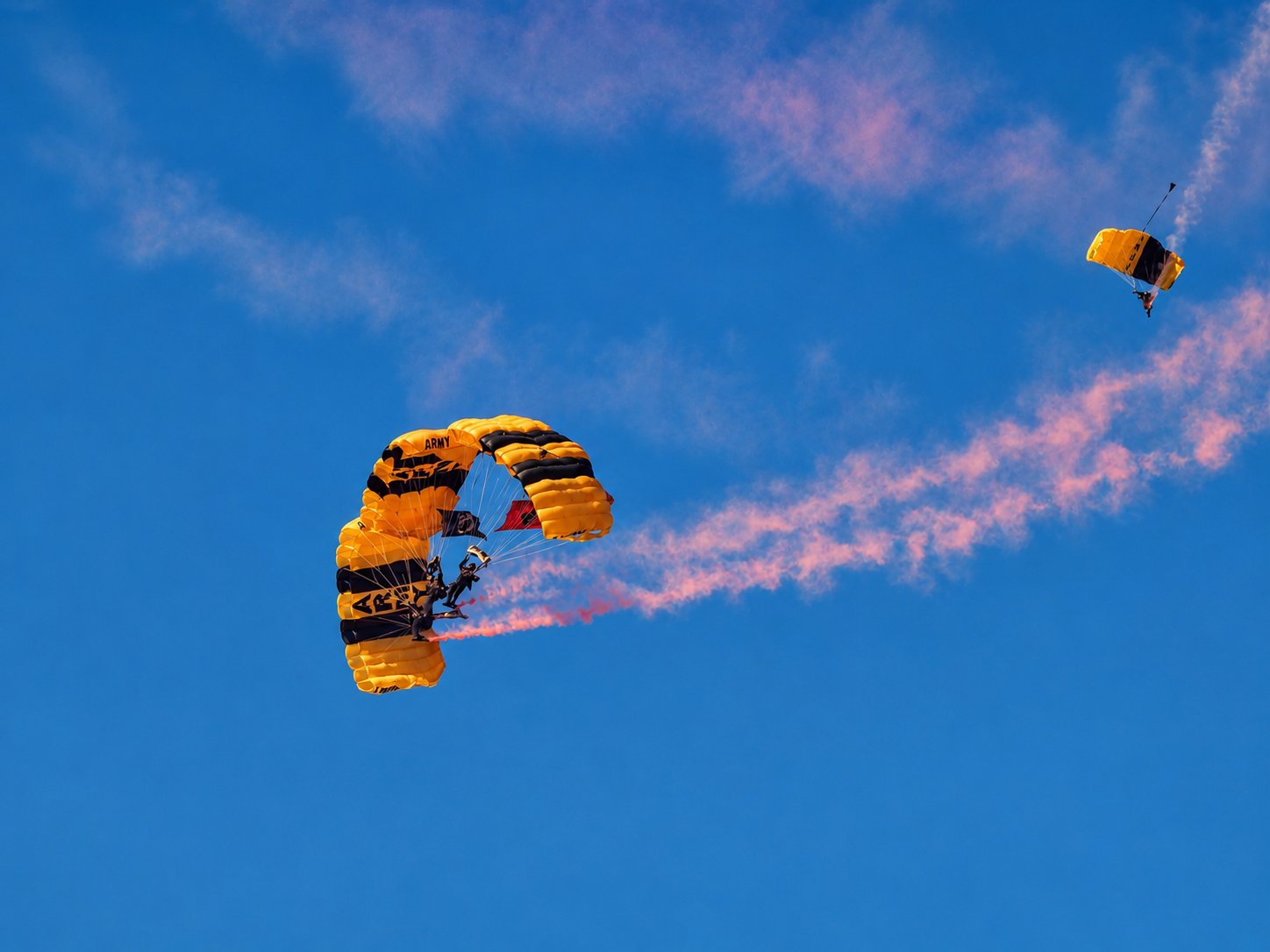 Members of the U.S. Army Golden Knights descend beneath parachutes during a precision aerial demonstration at the 100th Appalachian Fair in Gray, Tennessee. The Army’s official parachute team, established in 1959, performs demonstrations nationwide as part of its mission to represent the Army and showcase military free-fall skills. The Golden Knights were among the special attractions featured during the Aug. 22-29, 2026, centennial fair. [Photo: S Cobaugh, Aug. 27, 2026]