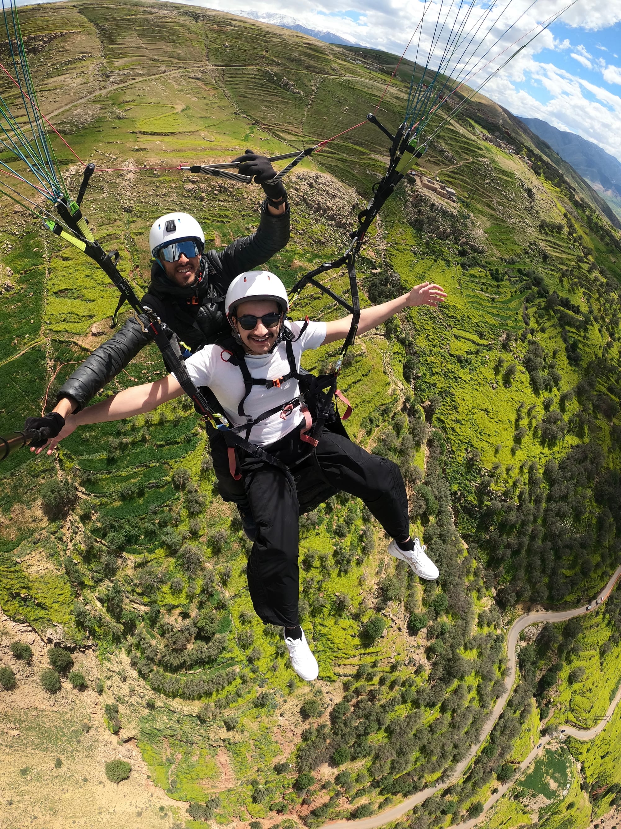Happy smiling customer enjoying the tandem paragliding experience mid flight