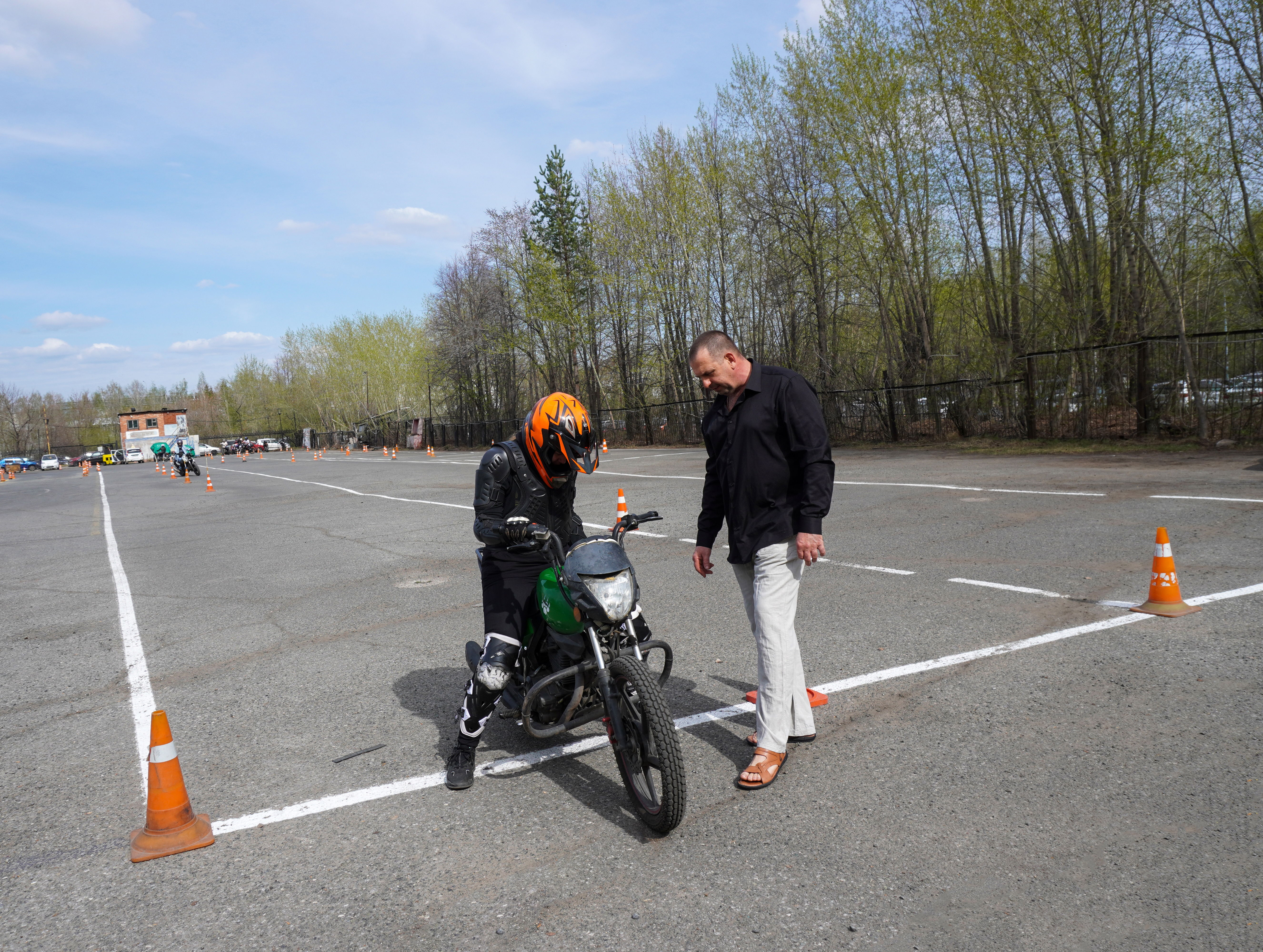 A beginner motorcyclist with full safety gear on a training course