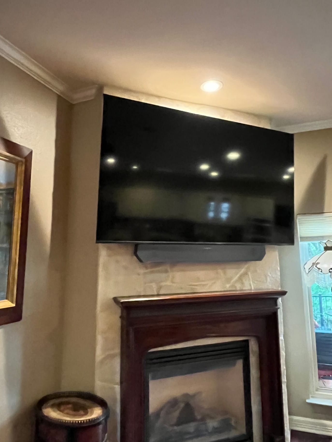 TV mounted above fireplace with tilt bracket