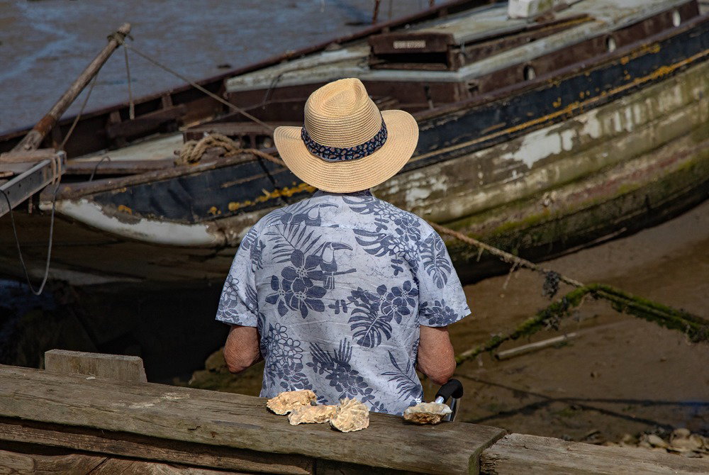 Steve in a Hat. The back of Steve Dines, keeping cool with a straw hat in the summer heat. Photograph by Chrissie Westgate.