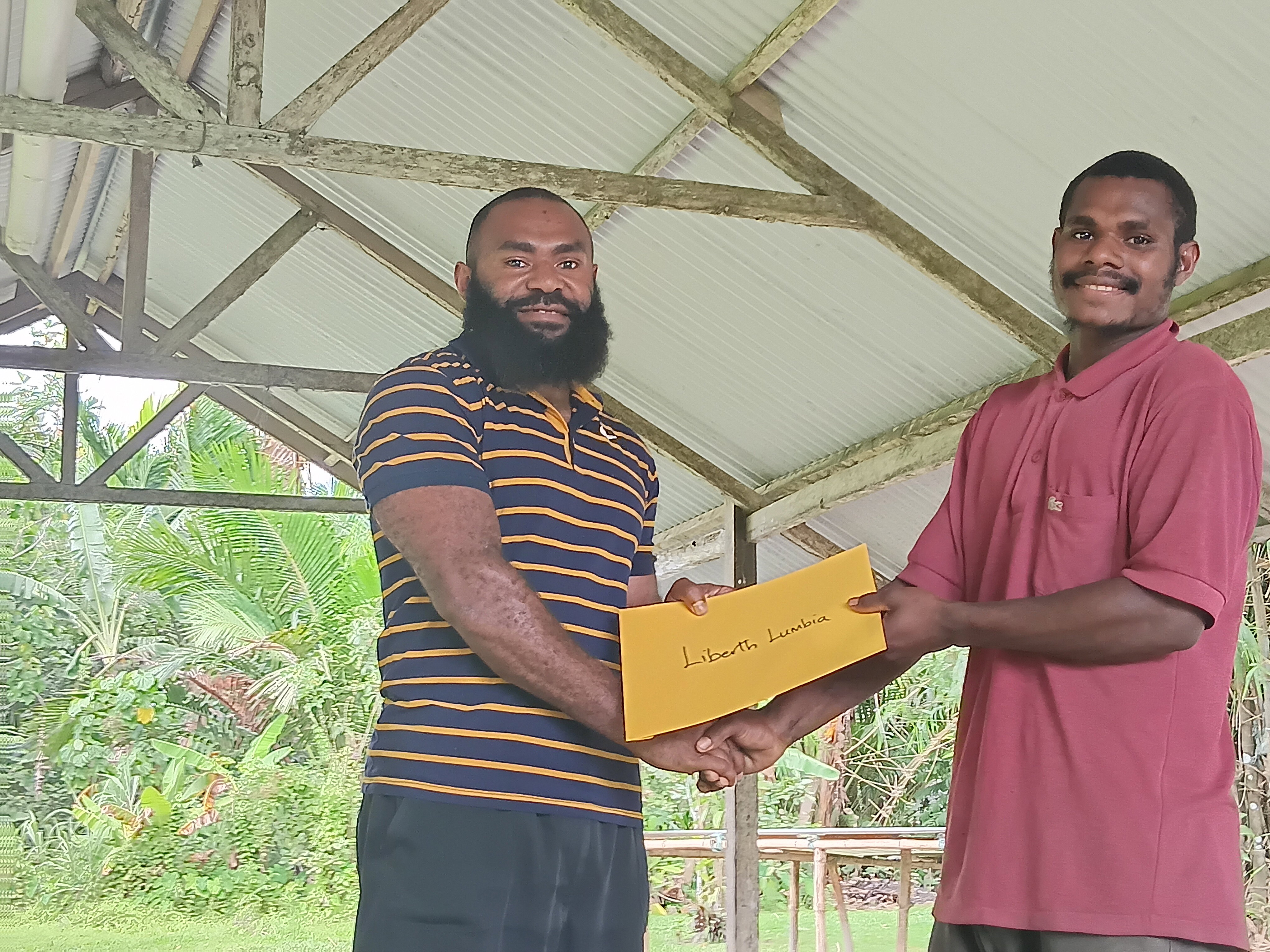 Presentation of certificate to by Mr. Jackson Mark (director) to Mr. Libert Lumbia, a youth out of few who attended.