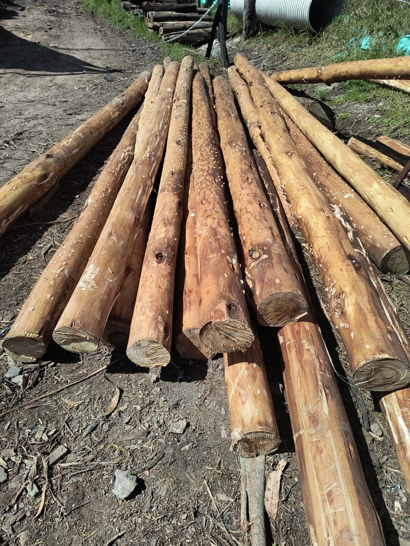 Madera rolliza descortezada o Postes con acabado limpio.