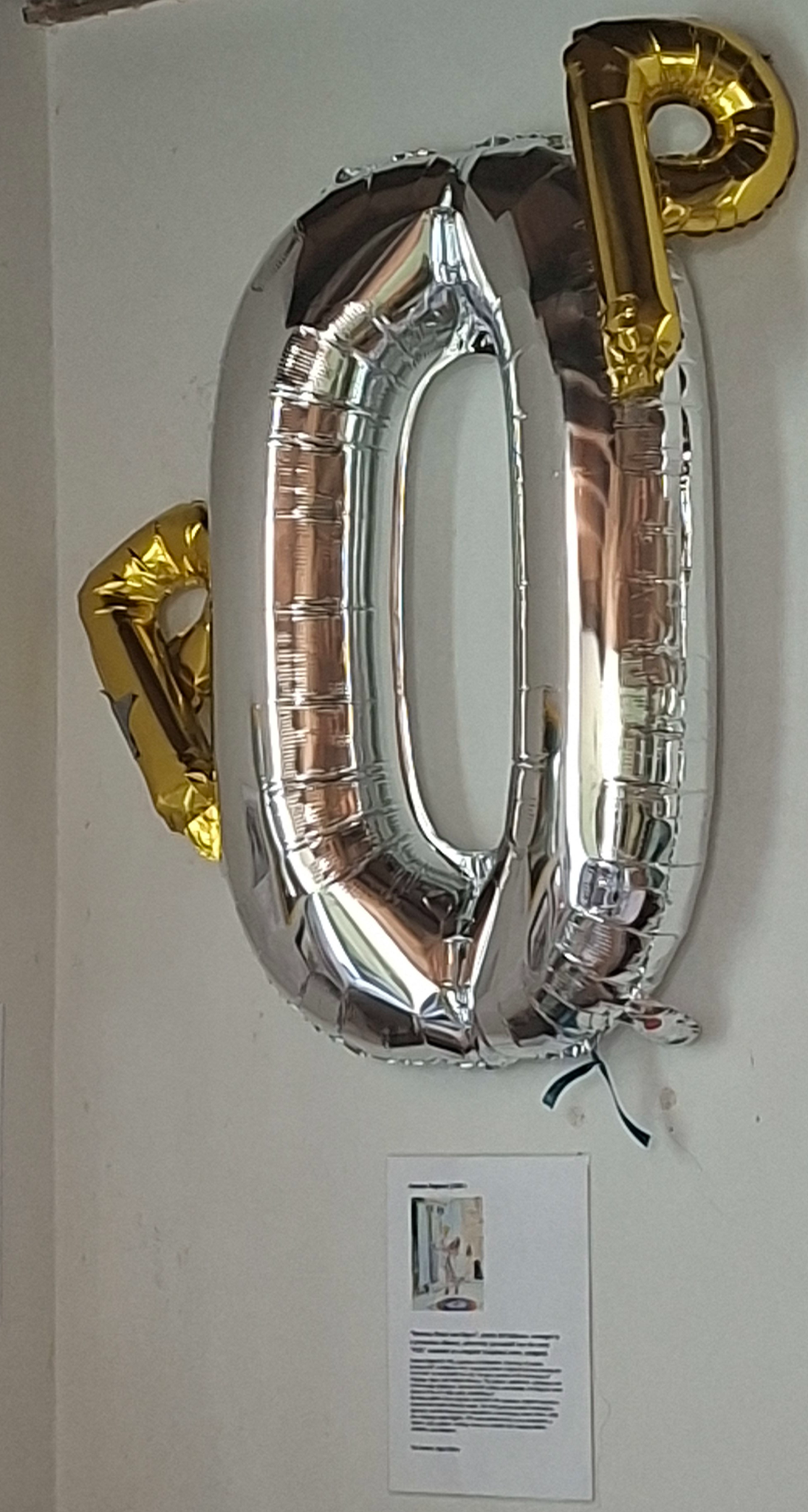 Gemma England (1989-)     “Between Event and Object”, plastic foil balloons, cut ribbon, arranged in a precarious alliance, adhesively persuaded into the word “POP,” mounted as a singular sculptural event, unsigned.