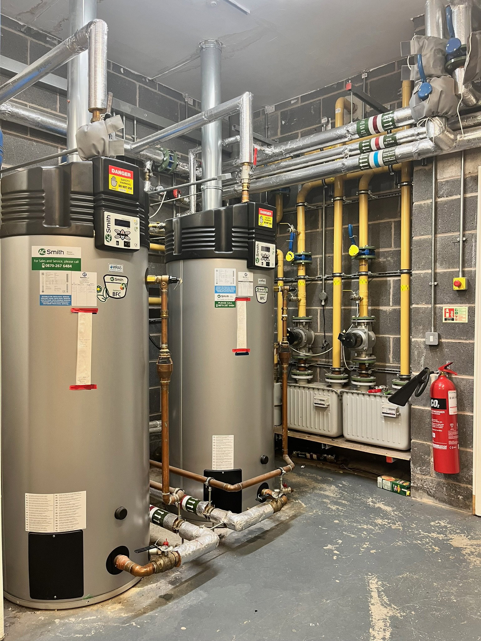 AO Smith commercial gas water heaters and gas pipework in a plant room – AAC Gas