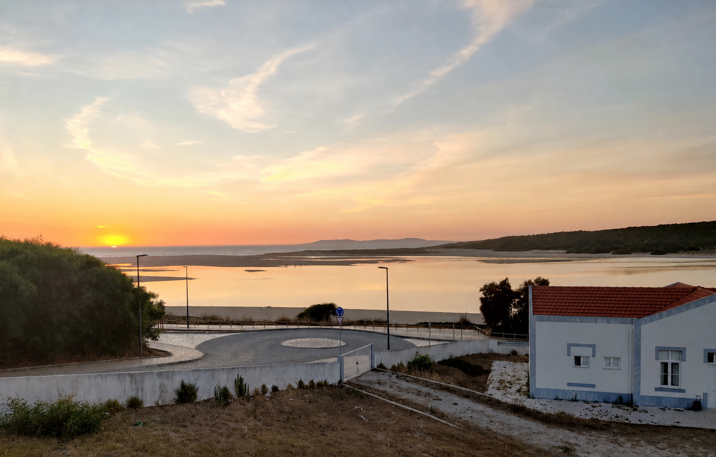 Sunset over the lagoon at Lagoa de Albufeira, Portugal, with traditional whitewashed house