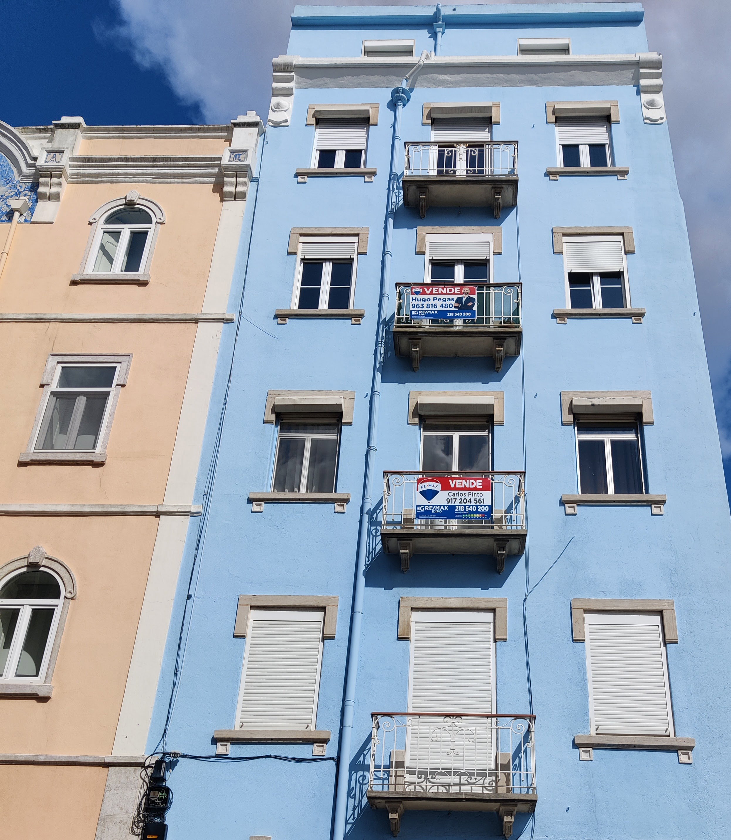 Vende signs on apartment balconies in Portugal, representing active property listings and asking-price data in the Portuguese real estate market.