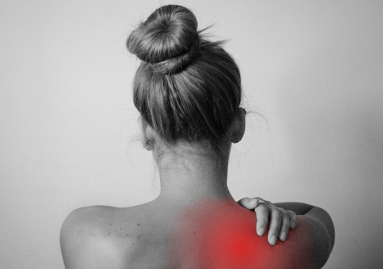 Woman holding shoulders due to posture-related pain