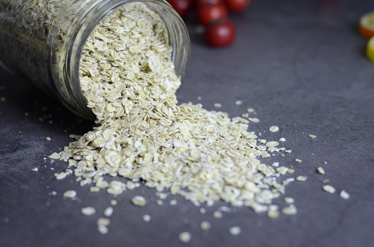 Oats poured from jar into glass for healthy energy food concept
