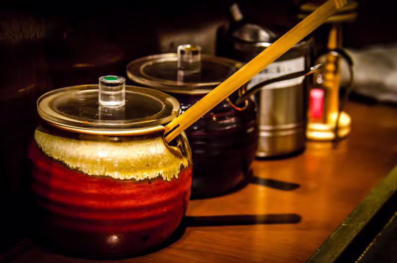 A warmly lit Kyoto restaurant counter set for dinner