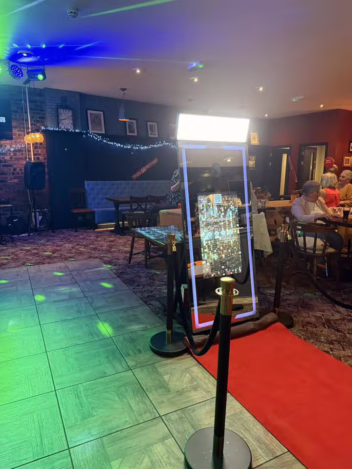 Guests smiling at a magic mirror photobooth