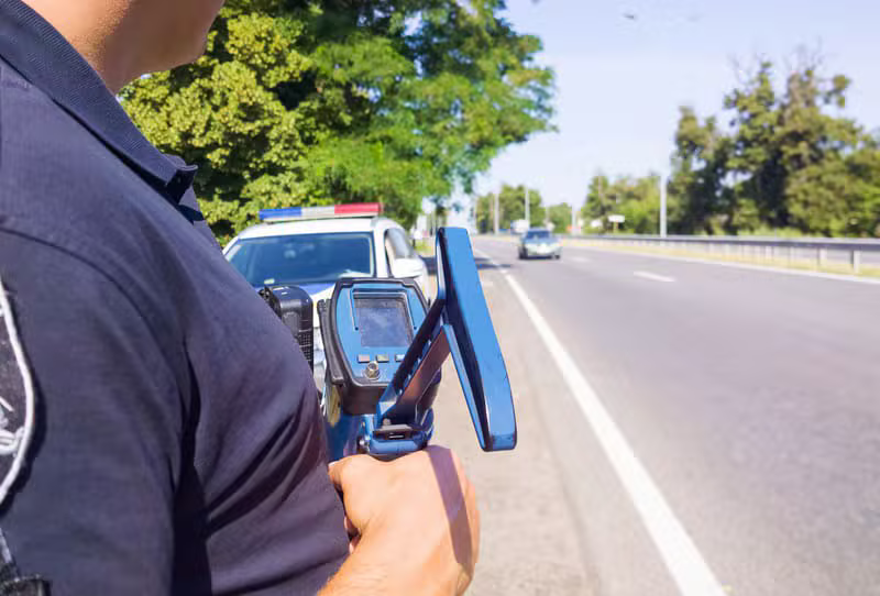 Police officer actively using a speed detection radar device