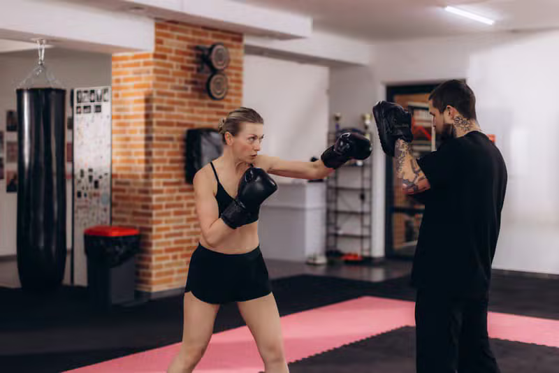 Boxing coach training a fighter with focus mitts