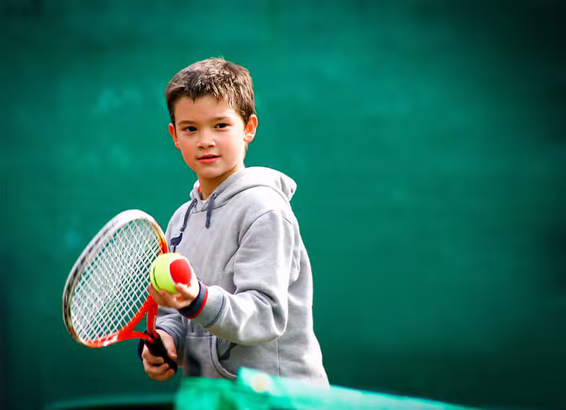 Smiling kid with tennis racket