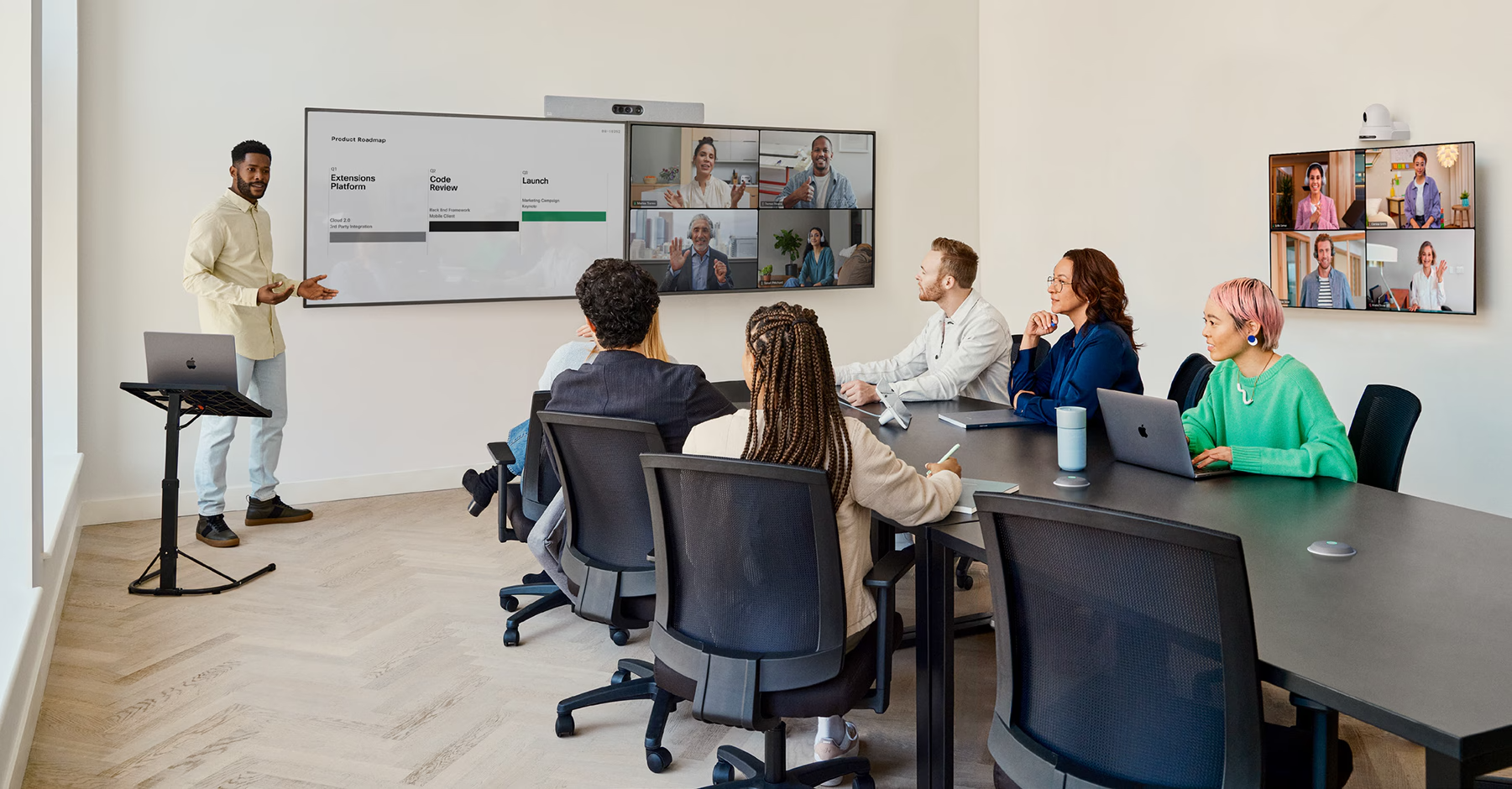 The Cisco Room Kit EQ in a conference room with the Quad Camera, the table-stand Room Navigator, and the Cisco Table Microphone Pro