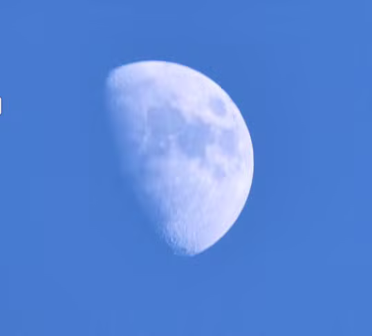 Half moon in clear blue sky