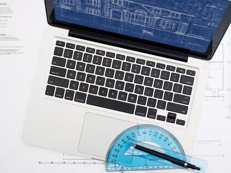 CAD drafting visible on a laptop screen