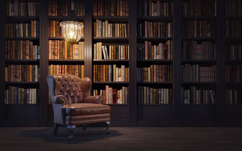 Persona leyendo libros antiguos en una biblioteca histórica