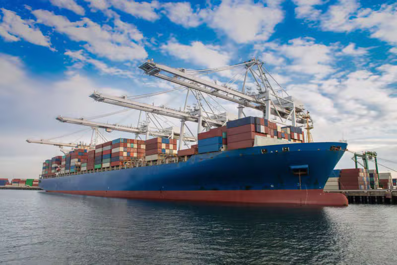 Port crane loading a bulk cargo vessel