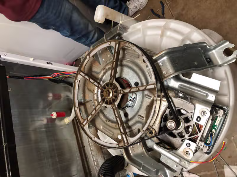 Technician servicing a combination washer and dryer unit