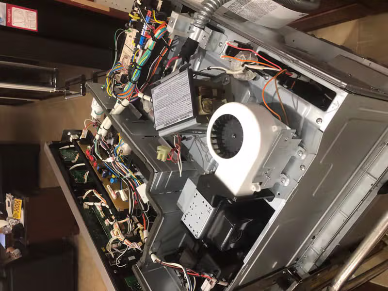 Technician working on a microwave repair