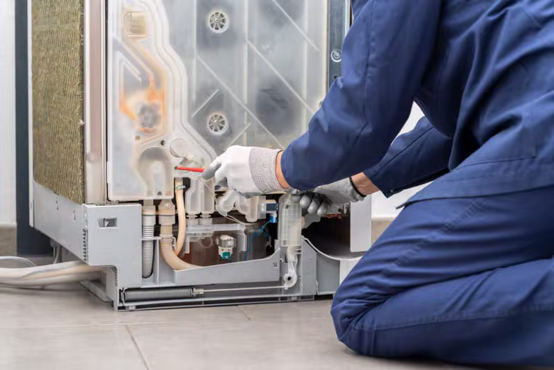 Worker repairing a front-load washing machine