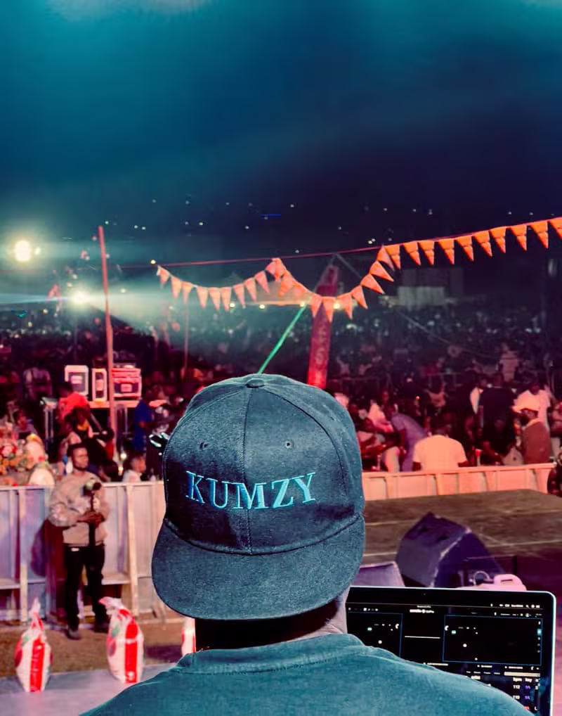 DJ Kumzy performing for a large outdoor crowd