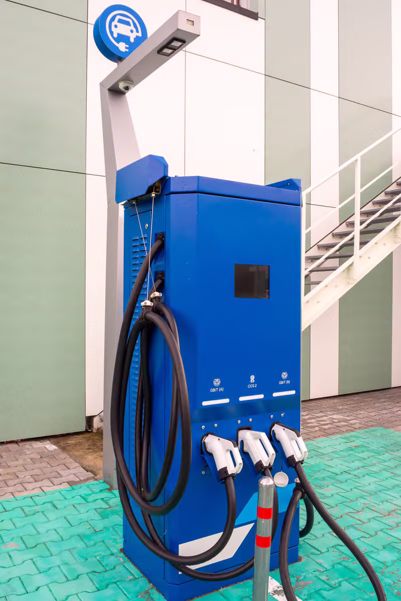 EV owner plugging in their vehicle at a charging station