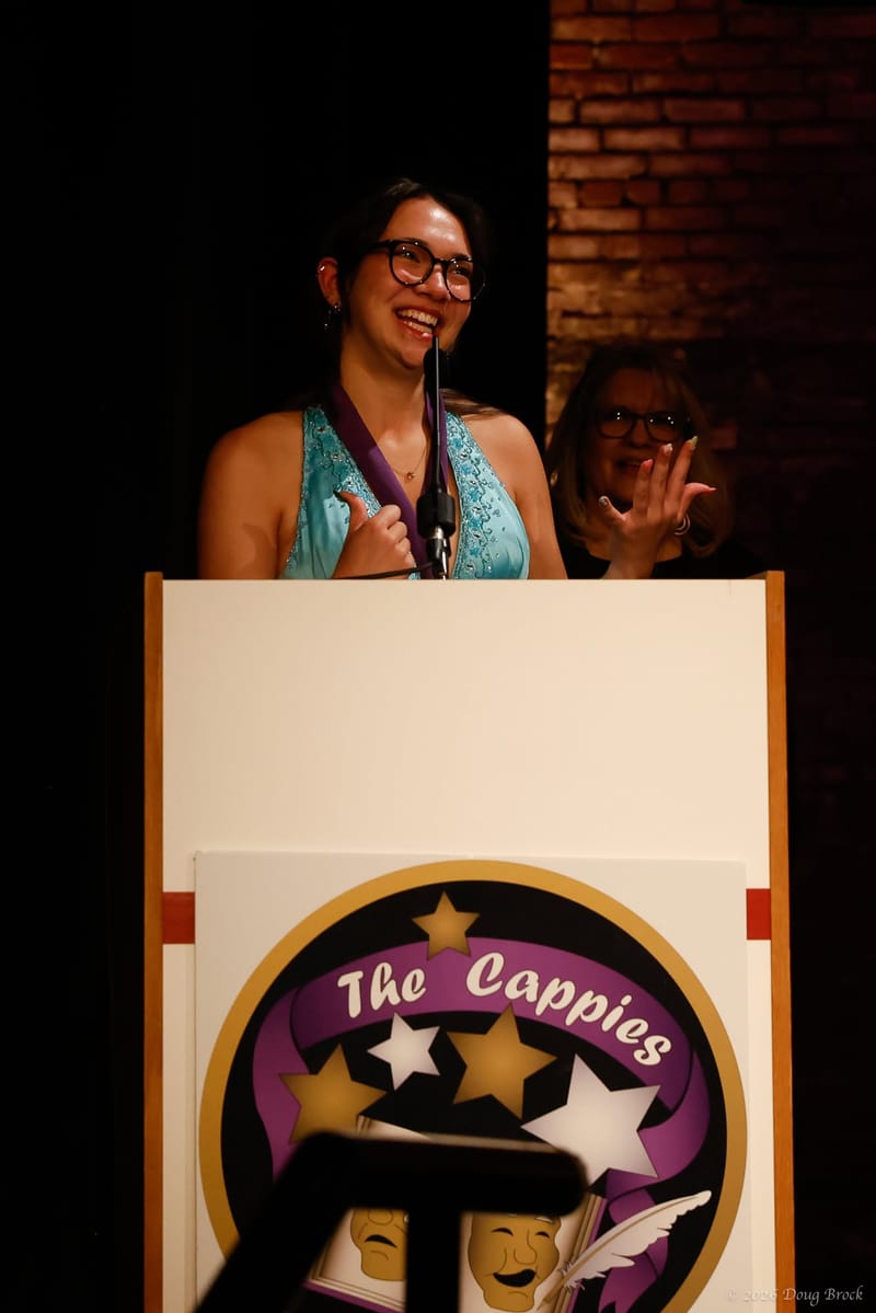 Teen critics writing notes in the audience of a theater
