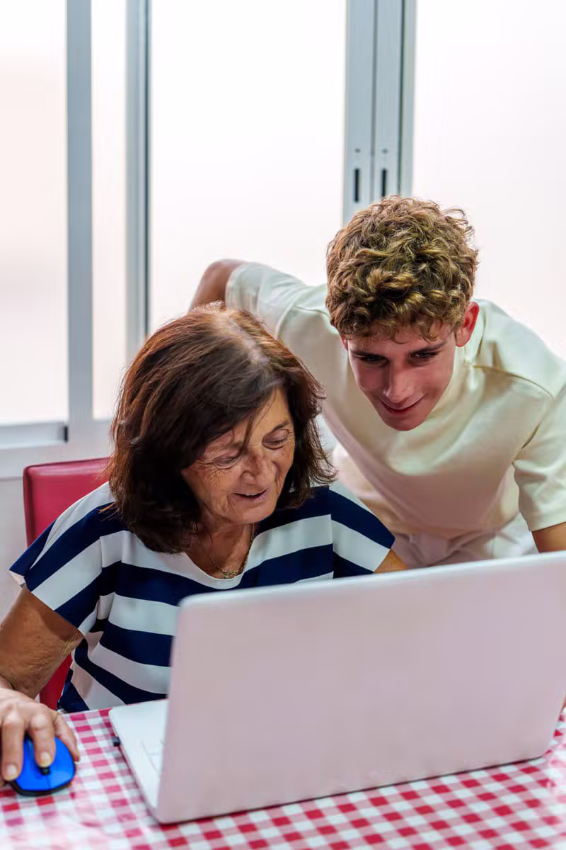 Étudiant aidant un senior avec le sourire