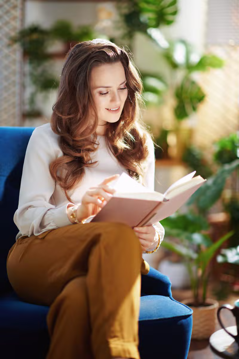 Femme avec un livre dans un jardin